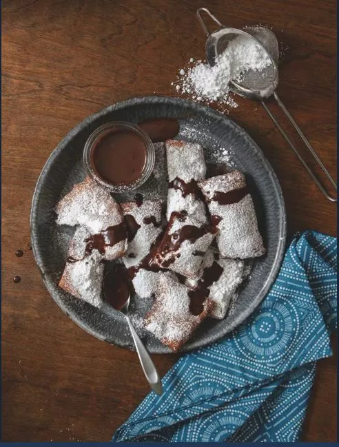 Drizzle the beignets with the hot chocolate sauce once they are fully baked. 